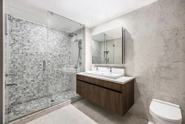 a bathroom with a sink a toilet and shower