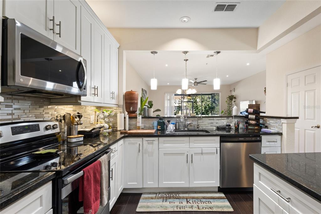 6435 Ranelagh Drive, Unit 104 Orlando, FL 32835 - Photo 13 of 36 a kitchen with a sink stove and microwave