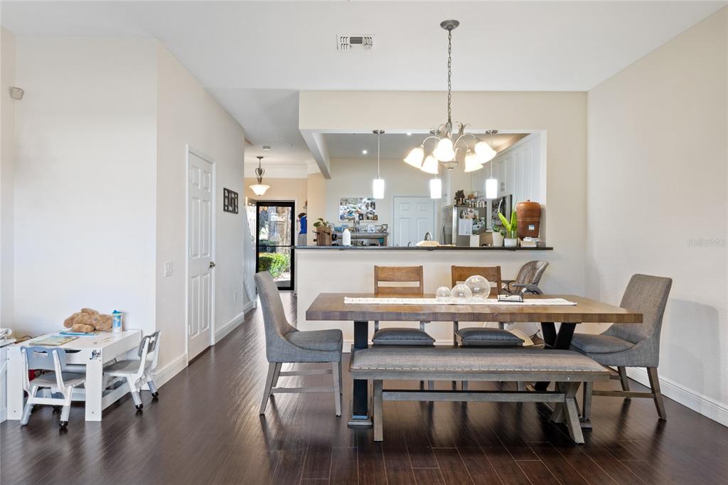 6435 Ranelagh Drive, Unit 104 Orlando, FL 32835 - Photo 9 of 36 a view of a dining room with furniture and wooden floor