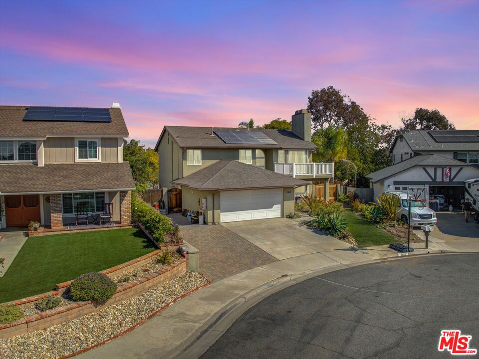 a front view of a house with a garden and yard