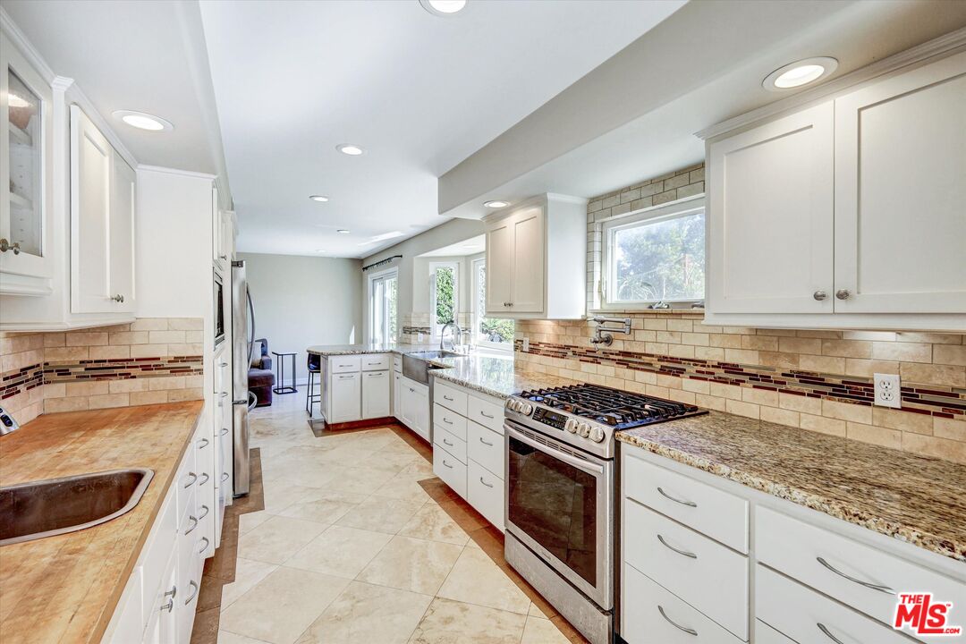 2868 Rutgers Place Oceanside, CA 92056 - Photo 11 of 34 a kitchen with stainless steel appliances granite countertop a stove top oven a sink a stove and white cabinets