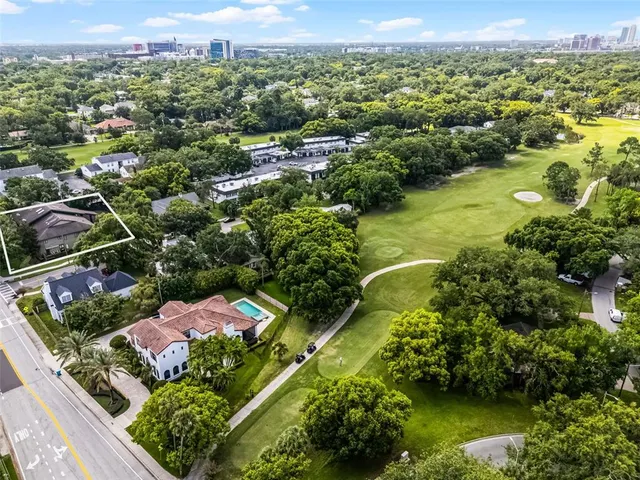 an aerial view of a houses with a garden and lake view