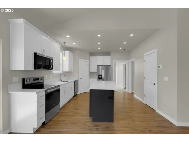 a kitchen with a sink refrigerator and cabinets