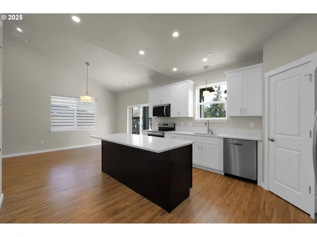 a kitchen with a sink a window and wooden floor