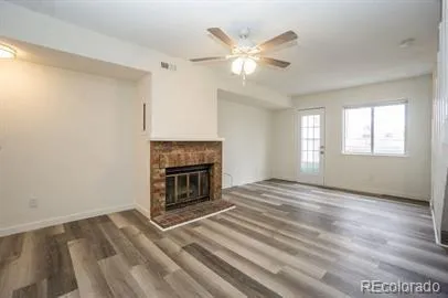 a view of a livingroom with a fireplace window and wooden floor