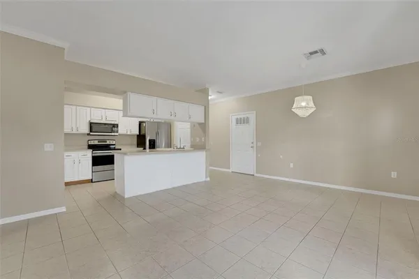 a view of kitchen with kitchen island white cabinets and stainless steel appliances