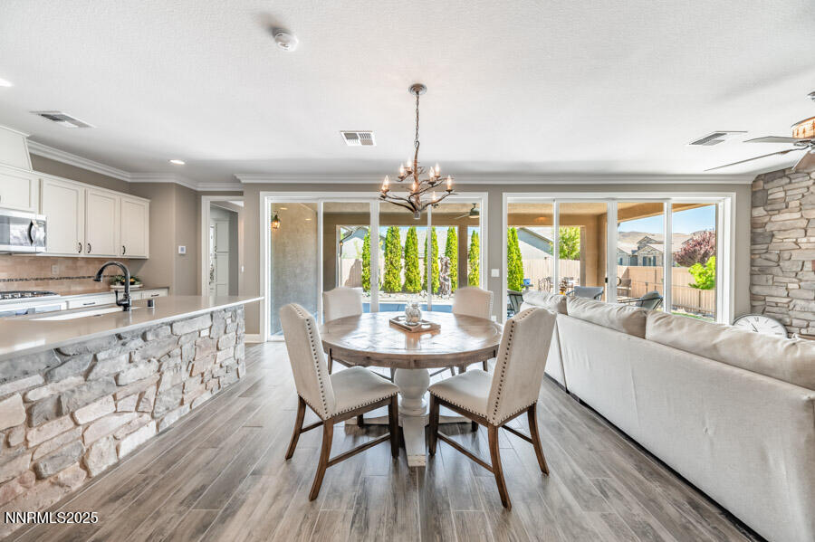 2295 Maximus Lane Reno, NV 89521 - Photo 7 of 62 a dining room with furniture a chandelier and wooden floor