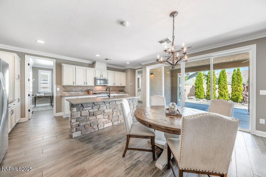 2295 Maximus Lane Reno, NV 89521 - Photo 8 of 62 a dining room with furniture a chandelier and wooden floor