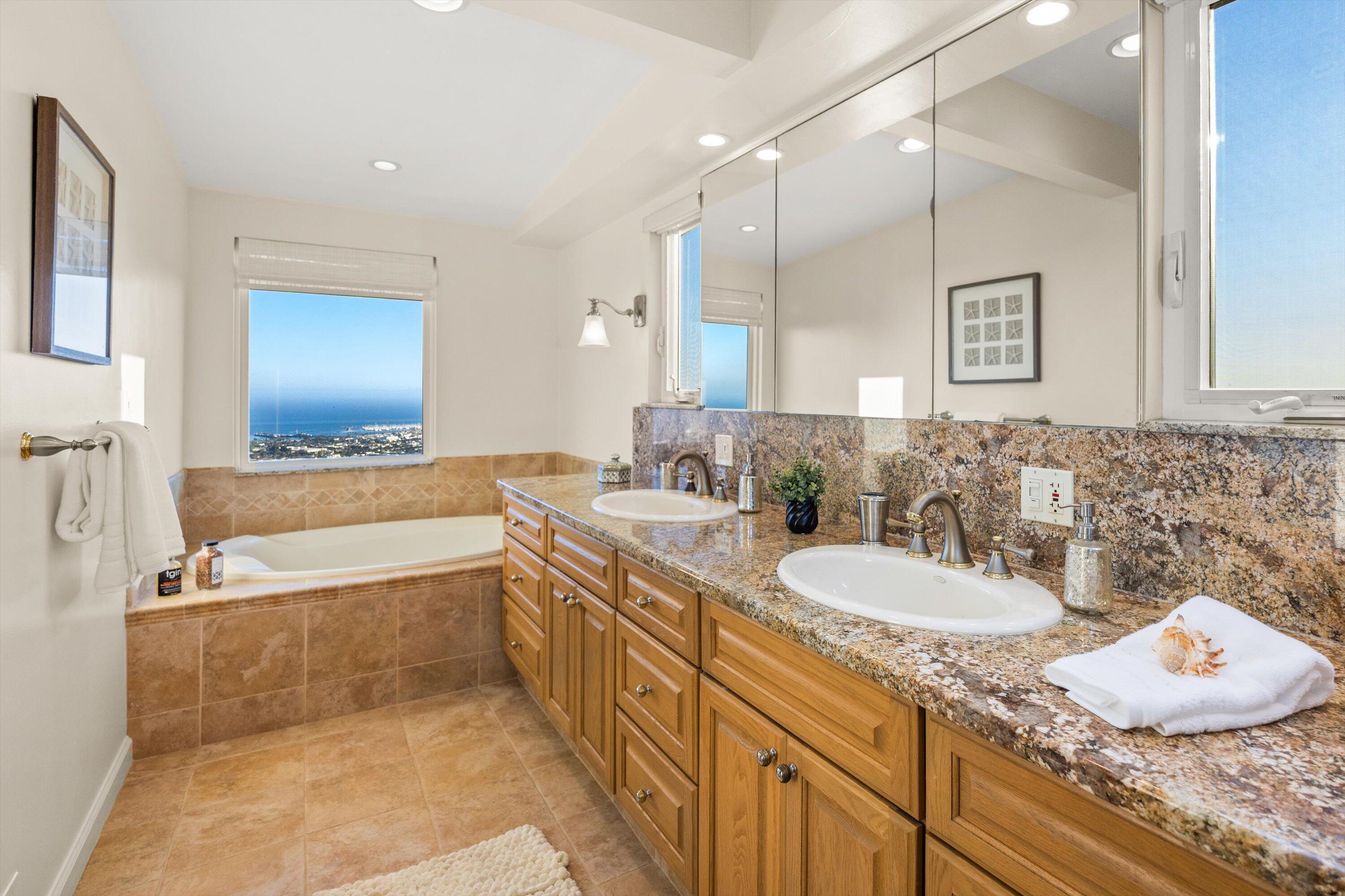 1227 Viscaino Road Santa Barbara, CA 93103 - Photo 16 of 25 a bathroom with a granite countertop tub sink and mirror