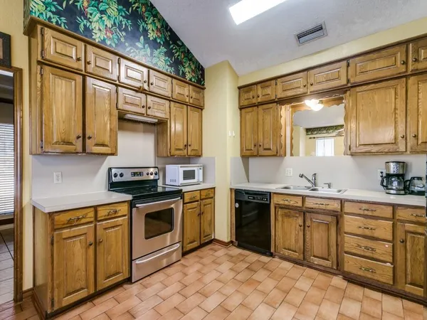 a kitchen with stainless steel appliances granite countertop a refrigerator a stove and a sink