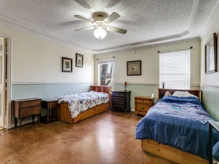 a spacious bedroom with a bed and a chandelier