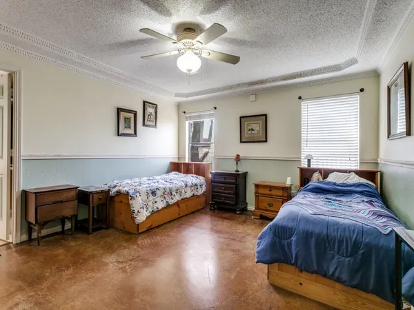 a spacious bedroom with a bed and a chandelier