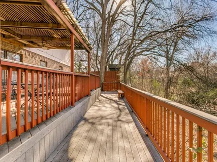 a view of a backyard with wooden fence and large trees