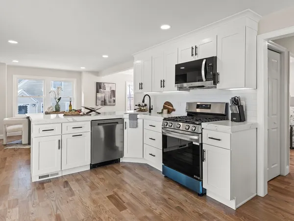 a kitchen with white cabinets stainless steel appliances and sink
