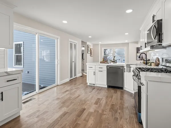 a kitchen with white cabinets and stainless steel appliances