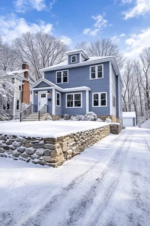 a front view of a house with a yard covered in snow