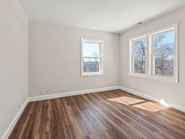 a view of a room with wooden floor