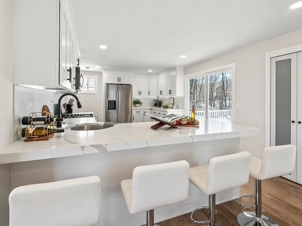 a kitchen with granite countertop a sink and a stove top oven with wooden floor