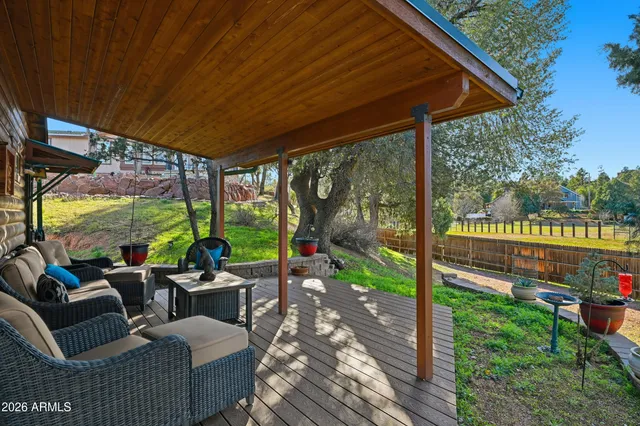 a backyard of a house with table and chairs and a large tree