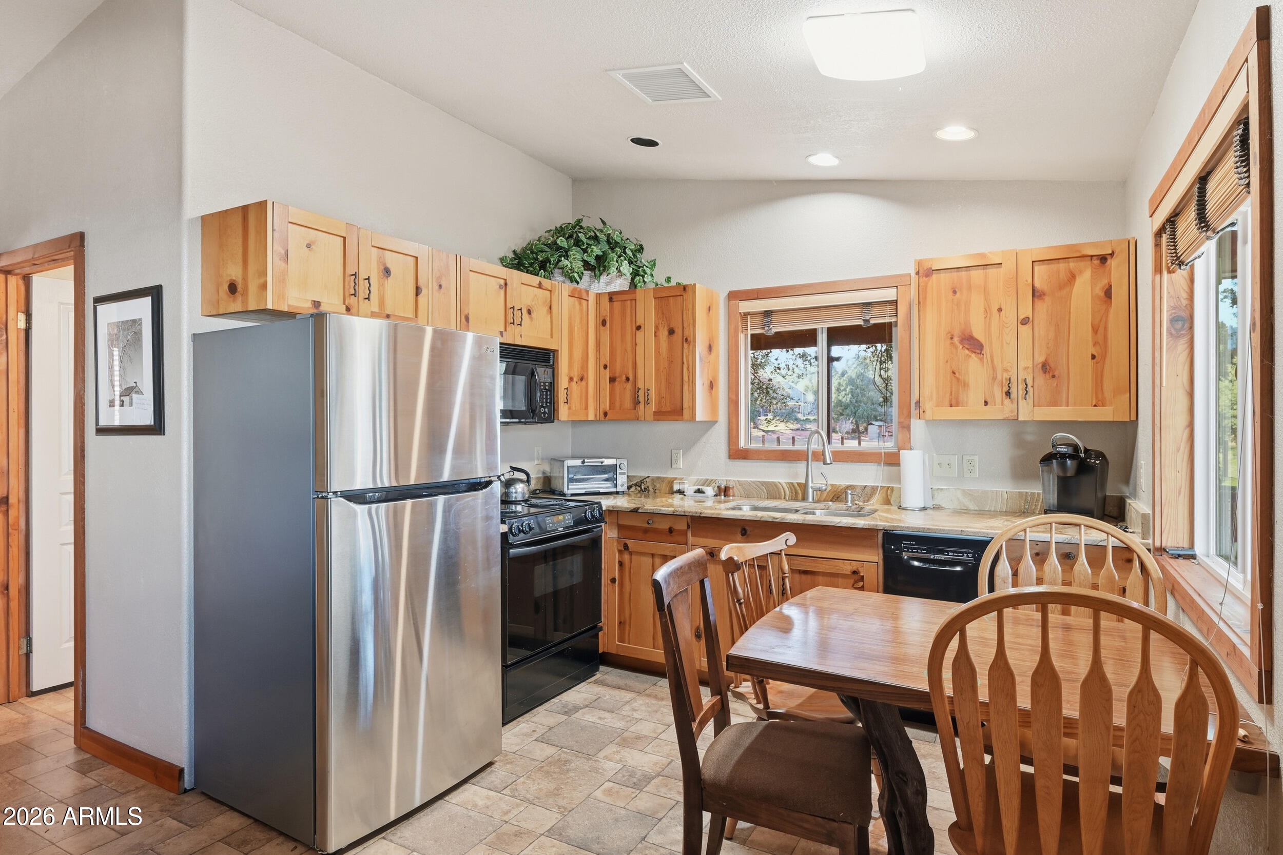 3933 Highway 260, Unit SP 256 Star Valley, AZ 85541 - Photo 6 of 28 a kitchen with stainless steel appliances granite countertop a refrigerator a stove a sink dishwasher a dining table and chairs with wooden floor
