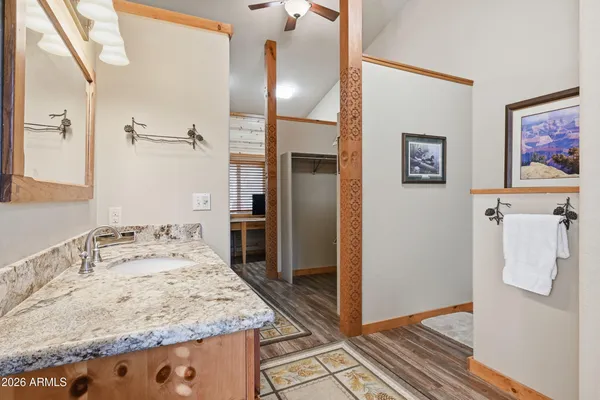 a bathroom with a granite countertop sink a mirror and shower