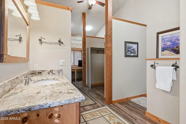 a bathroom with a granite countertop sink a mirror and shower