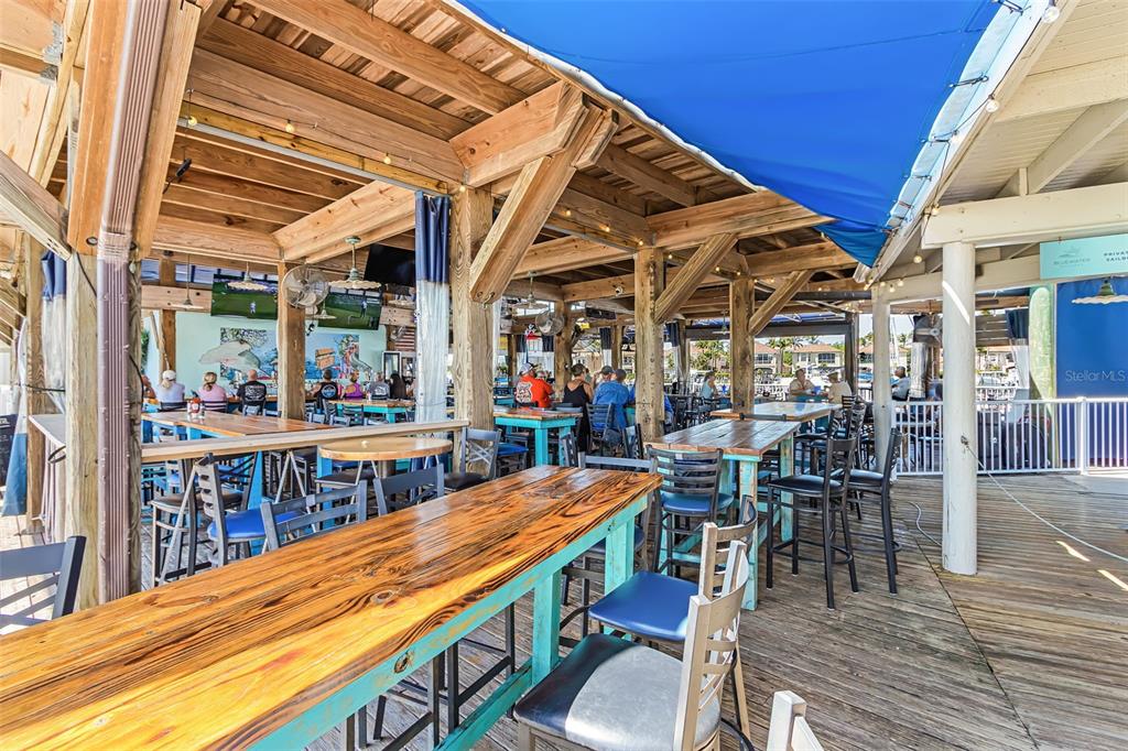 3312 Sunset Key Circle, Unit B Punta Gorda, FL 33955 - Photo 34 of 37 a view of a patio with table and chairs with wooden floor and fence