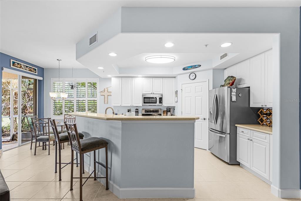 3312 Sunset Key Circle, Unit B Punta Gorda, FL 33955 - Photo 7 of 37 a kitchen with stainless steel appliances kitchen island granite countertop a refrigerator and a stove top oven