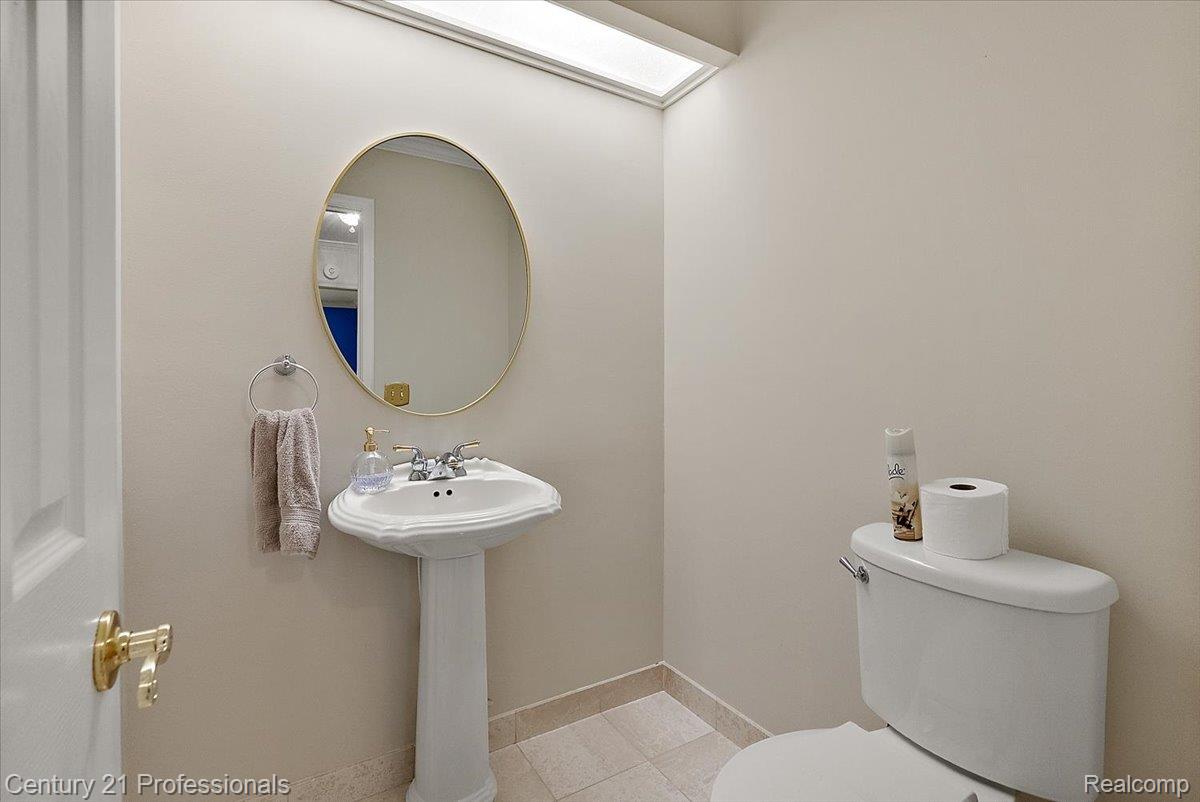 633 Foxhall Road Bloomfield Hills, MI 48304 - Photo 28 of 61 Pedestal sink with brass-framed oval mirror and recessed ceiling light