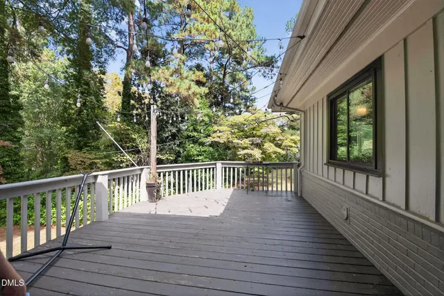 a view of a hallway with wooden floor and a kitchen