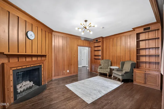 a view of a hallway with wooden floor and chandelier