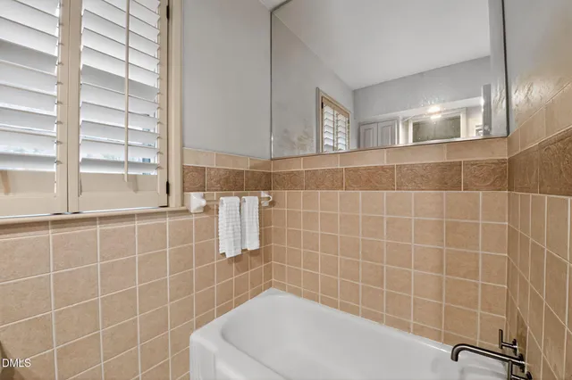 a bathroom with a sink a toilet a mirror and shower