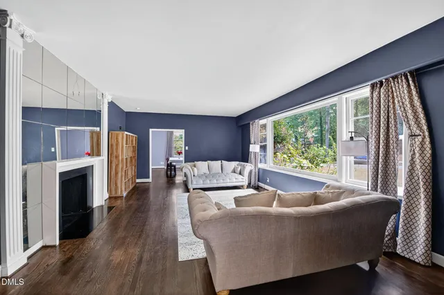 a living room with furniture and a open kitchen view