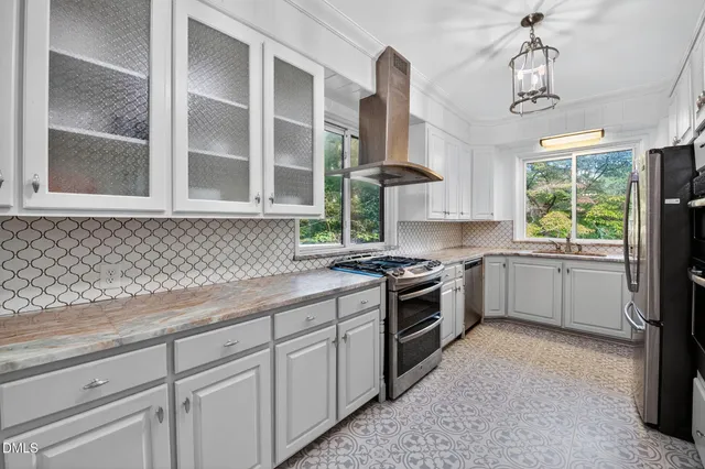 a kitchen with a sink cabinets appliances and a window