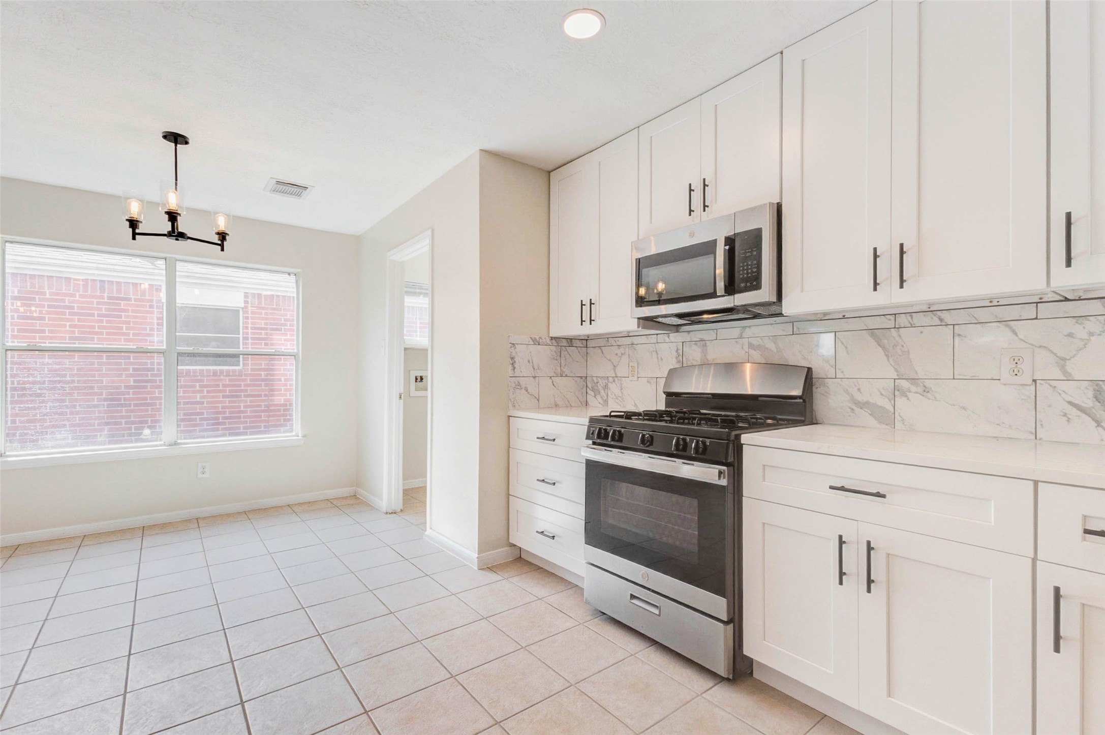 5318 Cilantro Lane Baytown, TX 77521 - Photo 11 of 45 a kitchen with stainless steel appliances granite countertop a stove a sink and a microwave