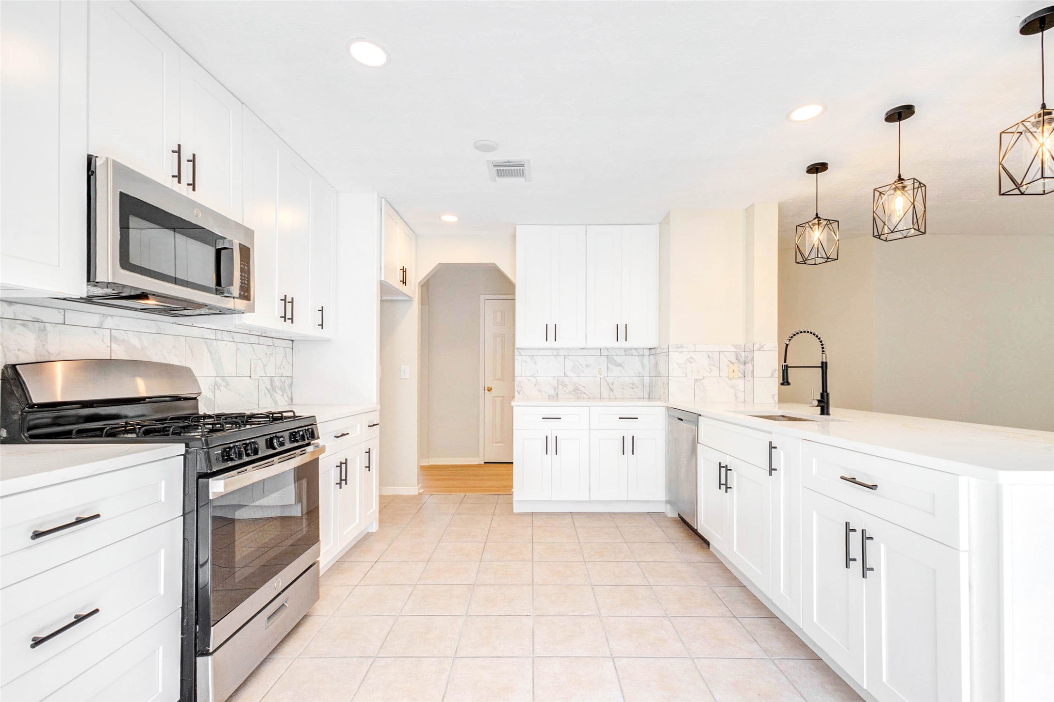 5318 Cilantro Lane Baytown, TX 77521 - Photo 13 of 45 a kitchen with stainless steel appliances a stove a sink and a refrigerator