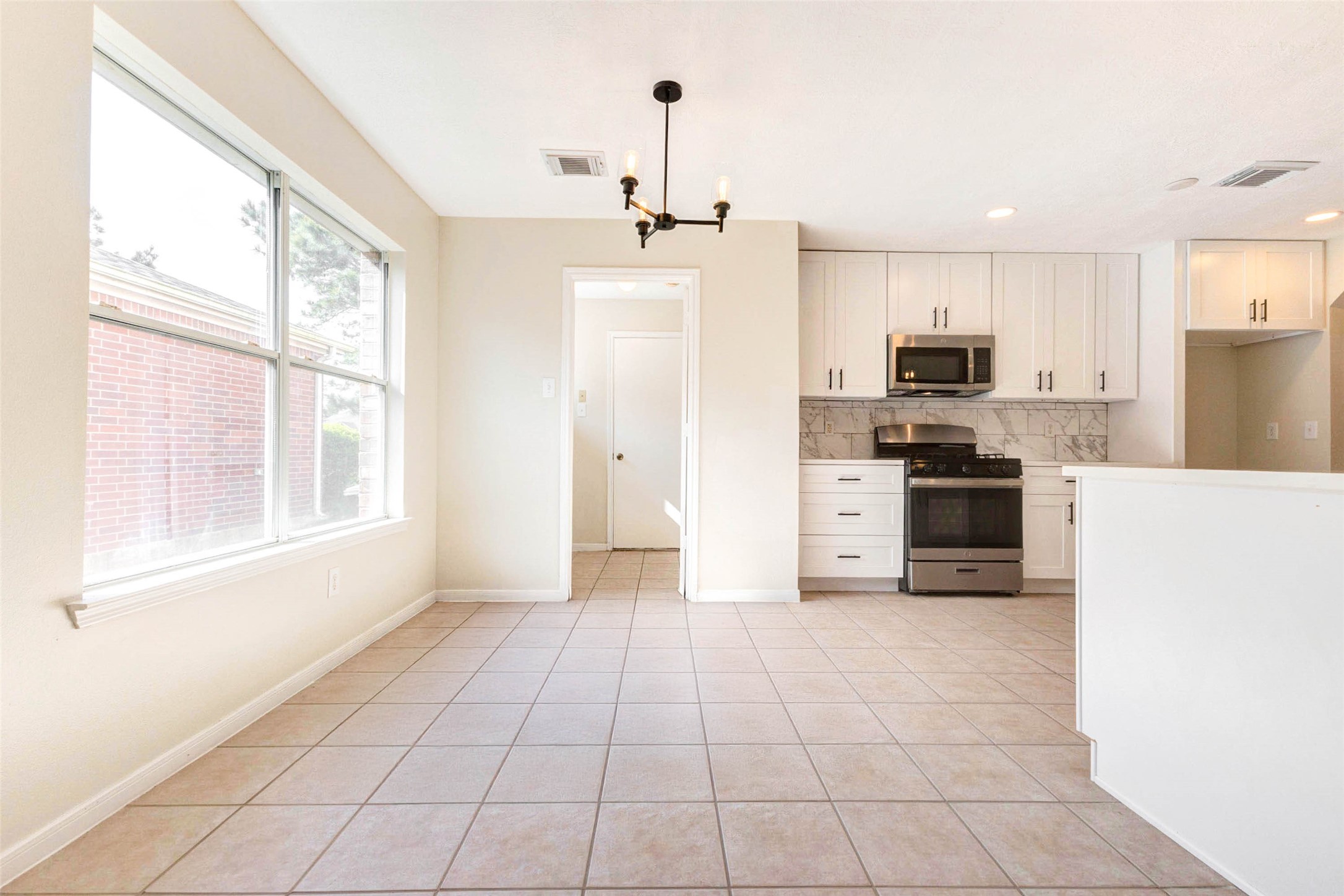 5318 Cilantro Lane Baytown, TX 77521 - Photo 19 of 45 a kitchen with kitchen island granite countertop a stove a sink and a refrigerator