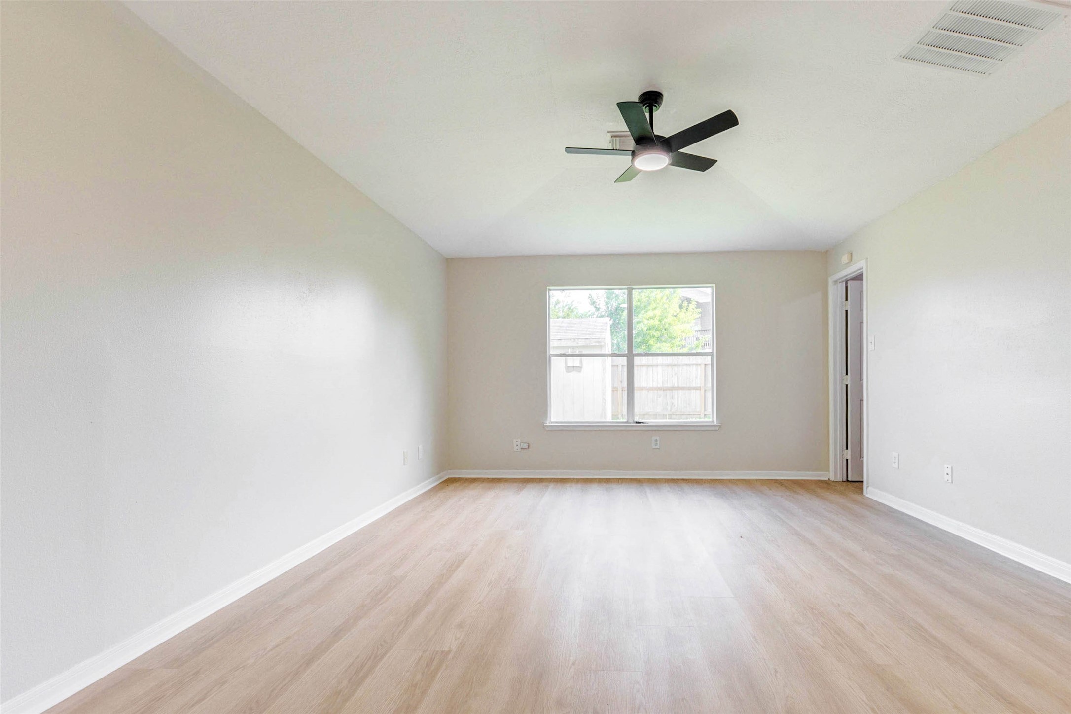 5318 Cilantro Lane Baytown, TX 77521 - Photo 24 of 45 an empty room with wooden floor fan and windows