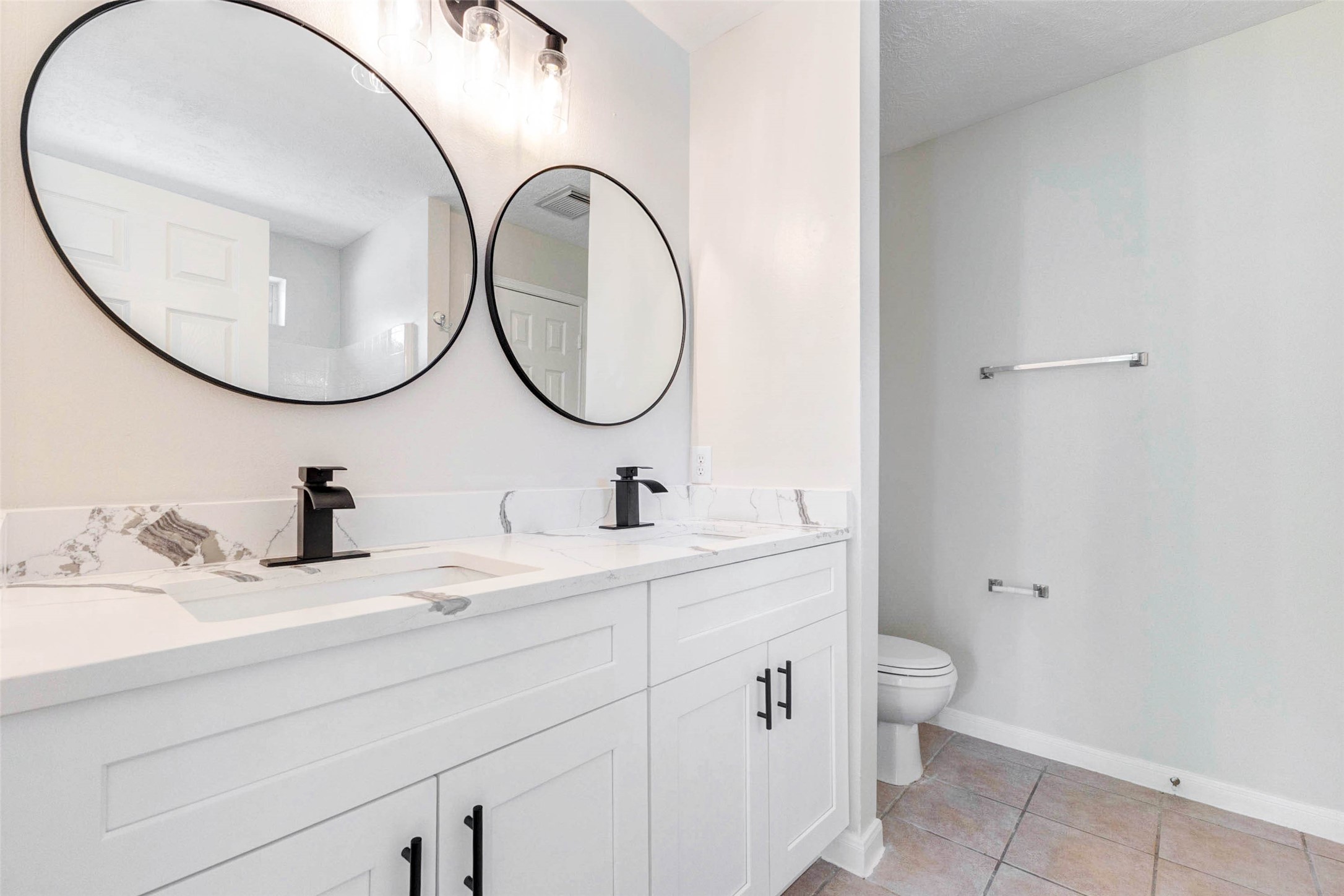 5318 Cilantro Lane Baytown, TX 77521 - Photo 26 of 45 a bathroom with a granite countertop toilet a sink and a mirror