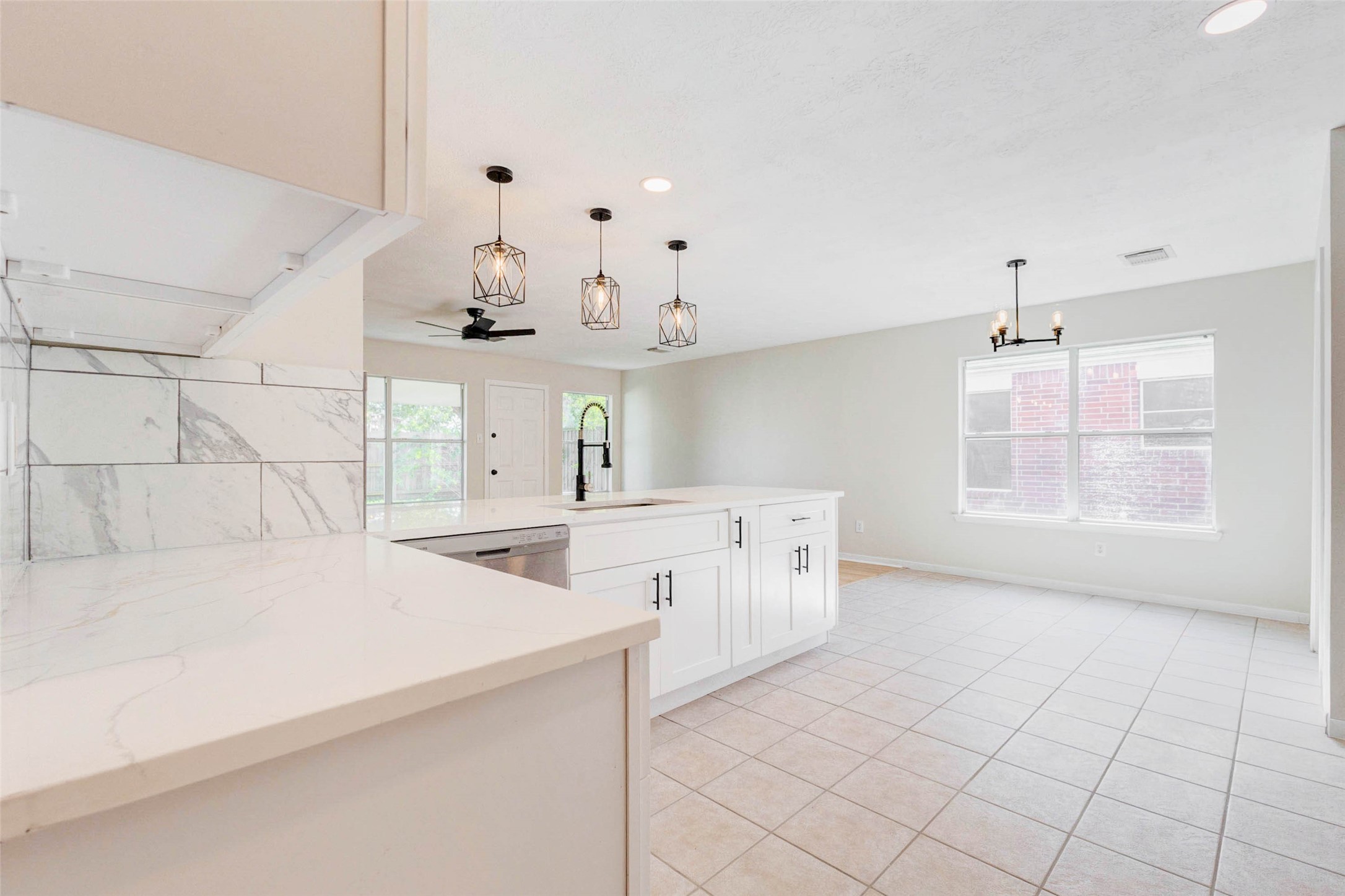 5318 Cilantro Lane Baytown, TX 77521 - Photo 10 of 45 a large white kitchen with a window and cabinets