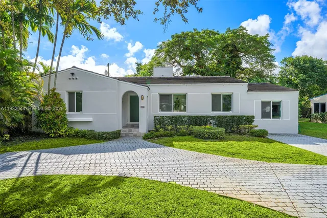 a front view of a house with a yard and potted plants