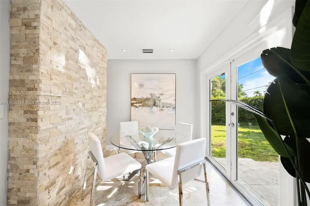 a dining room with furniture and a floor to ceiling window