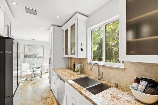 a kitchen with granite countertop a sink and a stove top oven
