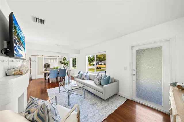 a living room with furniture a fireplace and a floor to ceiling window