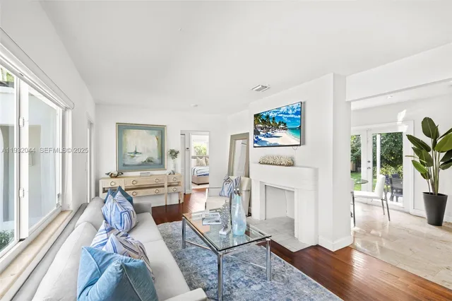 a living room with furniture a fireplace and a floor to ceiling window