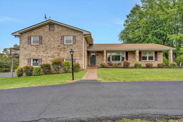 a front view of a house with a yard and potted plants