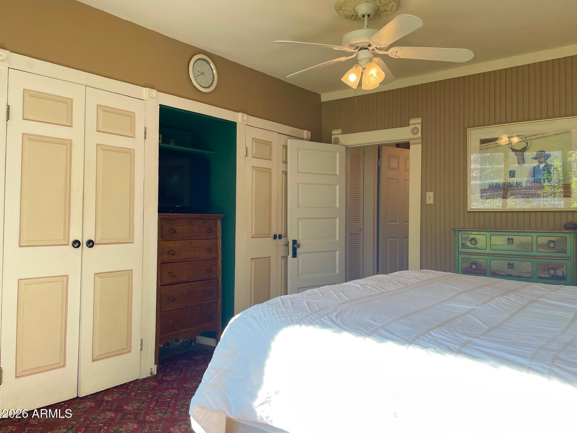 132 Opera Drive Bisbee, AZ 85603 - Photo 32 of 62 a spacious bedroom with a bed and a chandelier