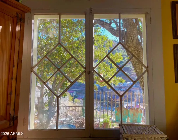 a backyard of a house with table and chairs under an umbrella