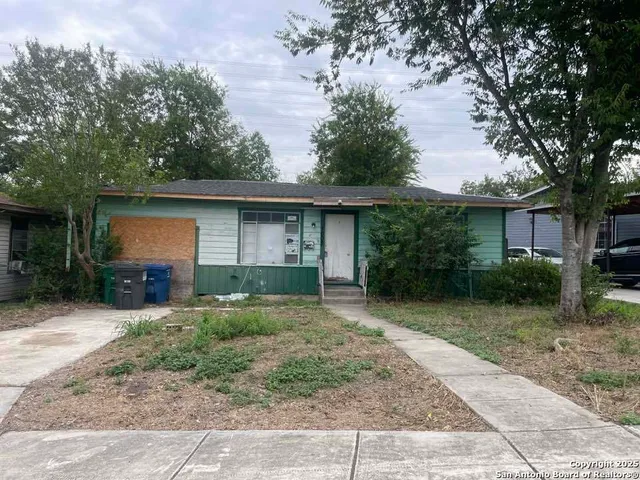 a view of a house with a yard and large tree