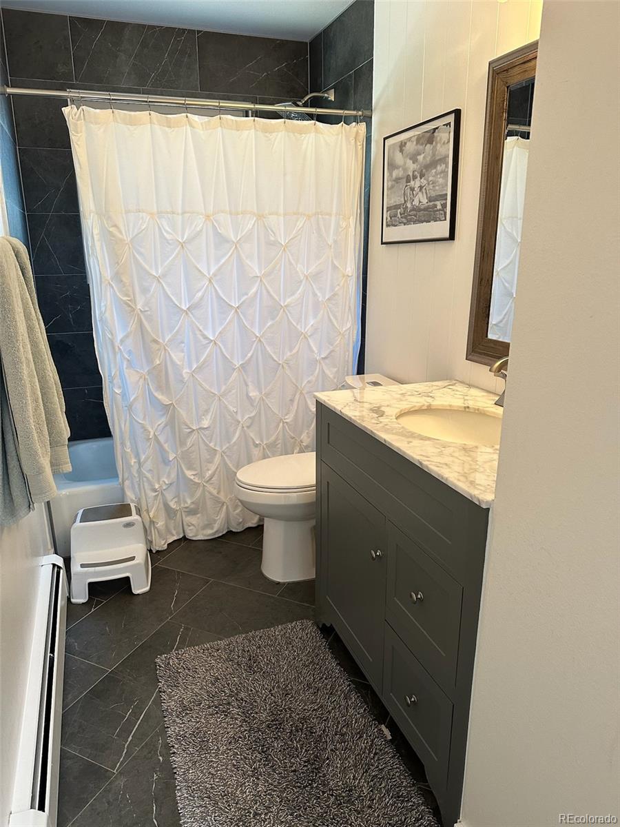 974 Wagon Trail Road Evergreen, CO 80439 - Photo 24 of 45 a bathroom with a granite countertop sink toilet and shower